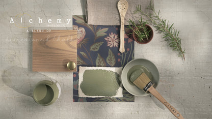 Flatlay inspiracional Alchemy by Fusion Rosemary con muestra de color verde herbáceo, bote abierto, brocha redonda, tirador dorado, papel botánico y rama de romero fresco sobre fondo de azulejo craquelado
