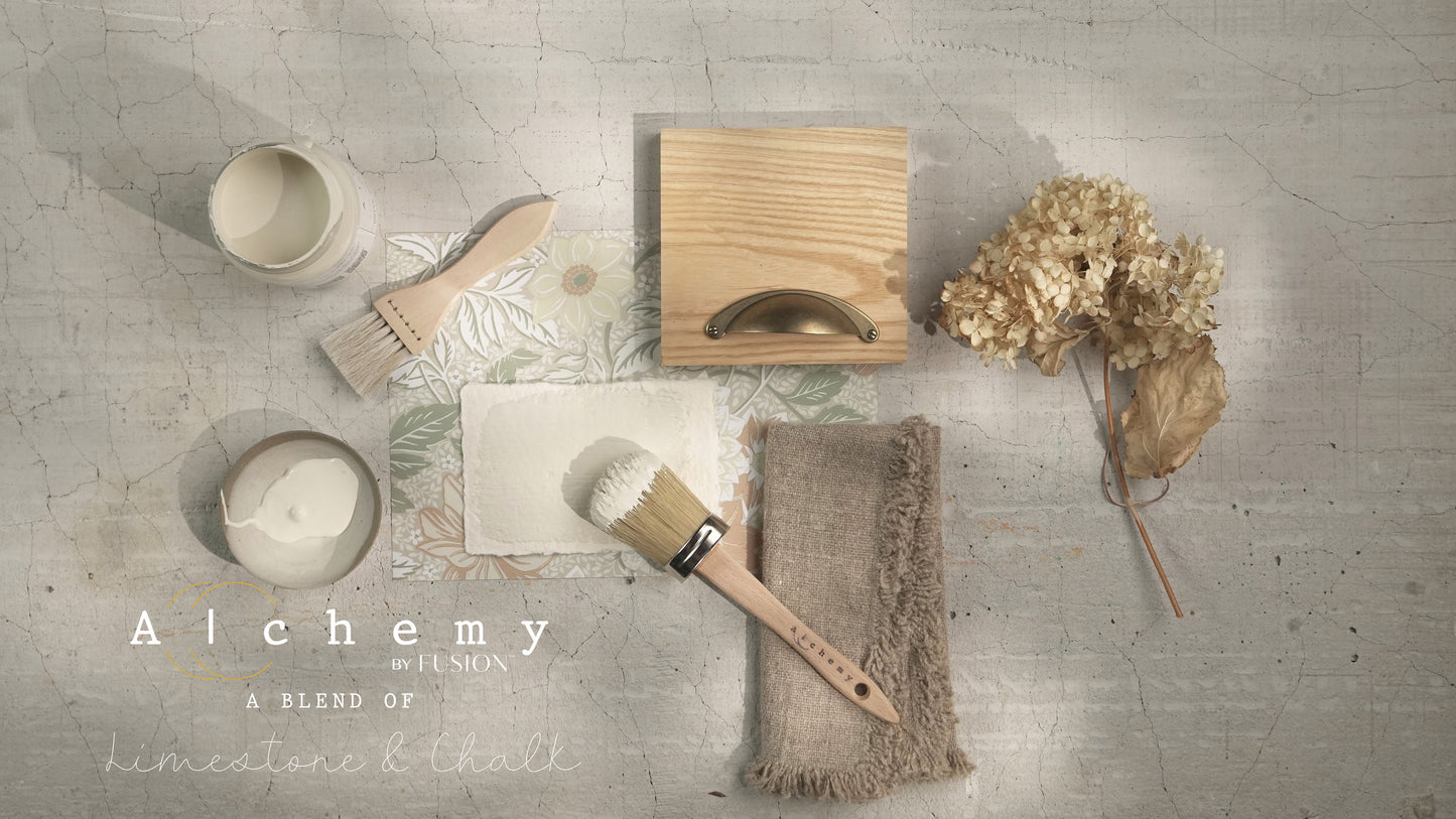 Flatlay inspiracional Alchemy by Fusion White Oak con muestra de color blanco roto, brocha plana, frente de cajón de madera natural con tirador dorado, tela de lino y hortensia seca sobre fondo de azulejo craquelado blanco