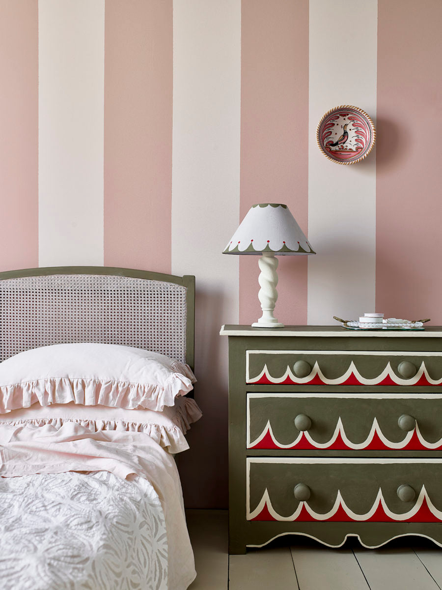 Dormitorio con pared en Wall Paint Piranesi Pink, cama y arcón en Olive, y detalles en Old Ochre y Emperor's Silk de Annie Sloan