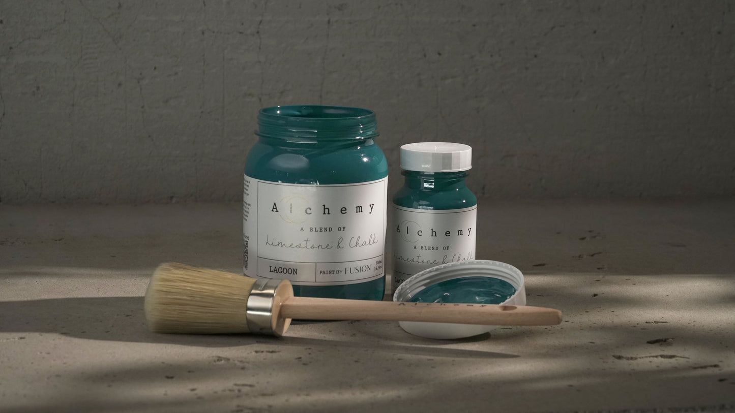 Botes Alchemy by Fusion Lagoon 500ml y 120ml con brocha sobre superficie de cemento, pintura a la tiza verde azulado teal