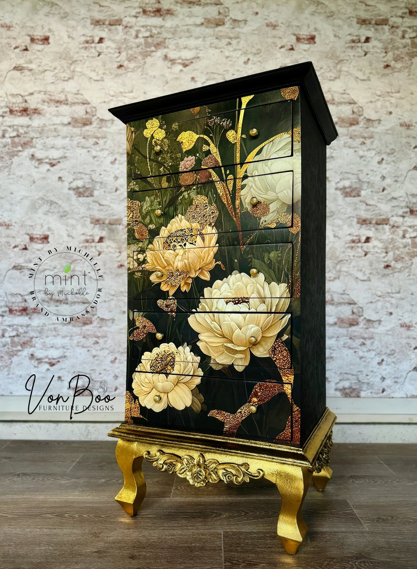 Papel decoupage Autumn Blossoms de Mint by Michelle en cómoda negra con patas doradas — flores otoñales en crema, dorado y verde oscuro, estilo botánico lujoso