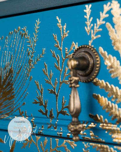 Detalle macro de transferencia Foliage Finesse Kacha sobre cajón azul teal - helechos y follaje dorado con tirador de bronce antiguo - Re-Design with Prima
