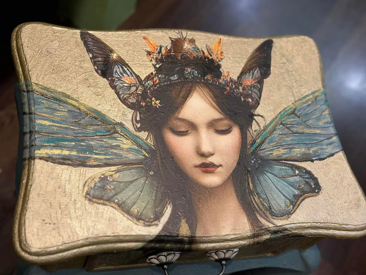 Papel decoupage Fairy Princess de Mint by Michelle aplicado en caja decorativa — hada con alas de mariposa azul turquesa y corona de mariposas, estilo pictórico vintage
