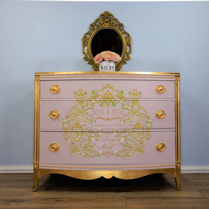 Transferencia decorativa Petit à Petit Kacha en cómoda rosa palo estilo Luis XVI restaurada con detalles dorados - arabescos florales dorados y texto Son Nid, espejo barroco dorado - Re-Design with Prima
