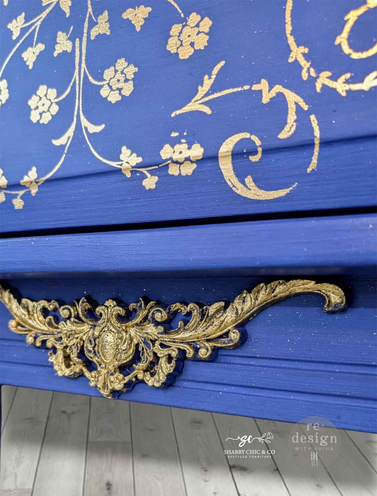 Detalle de transferencia Manor Swirls Kacha sobre cajón azul cobalto - espirales dorados y blancos con tirador barroco dorado - Re-Design with Prima