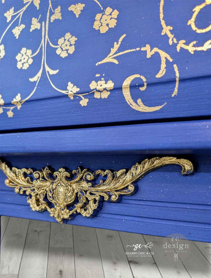 Detalle de transferencia Manor Swirls Kacha sobre cajón azul cobalto - espirales dorados y blancos con tirador barroco dorado - Re-Design with Prima